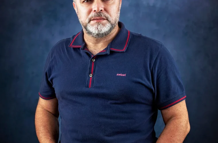 Homem adulto usando polo azul-marinho em composição casual